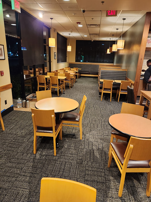 Commercial dining hall with patterned carpet tile, tables and chairs in place