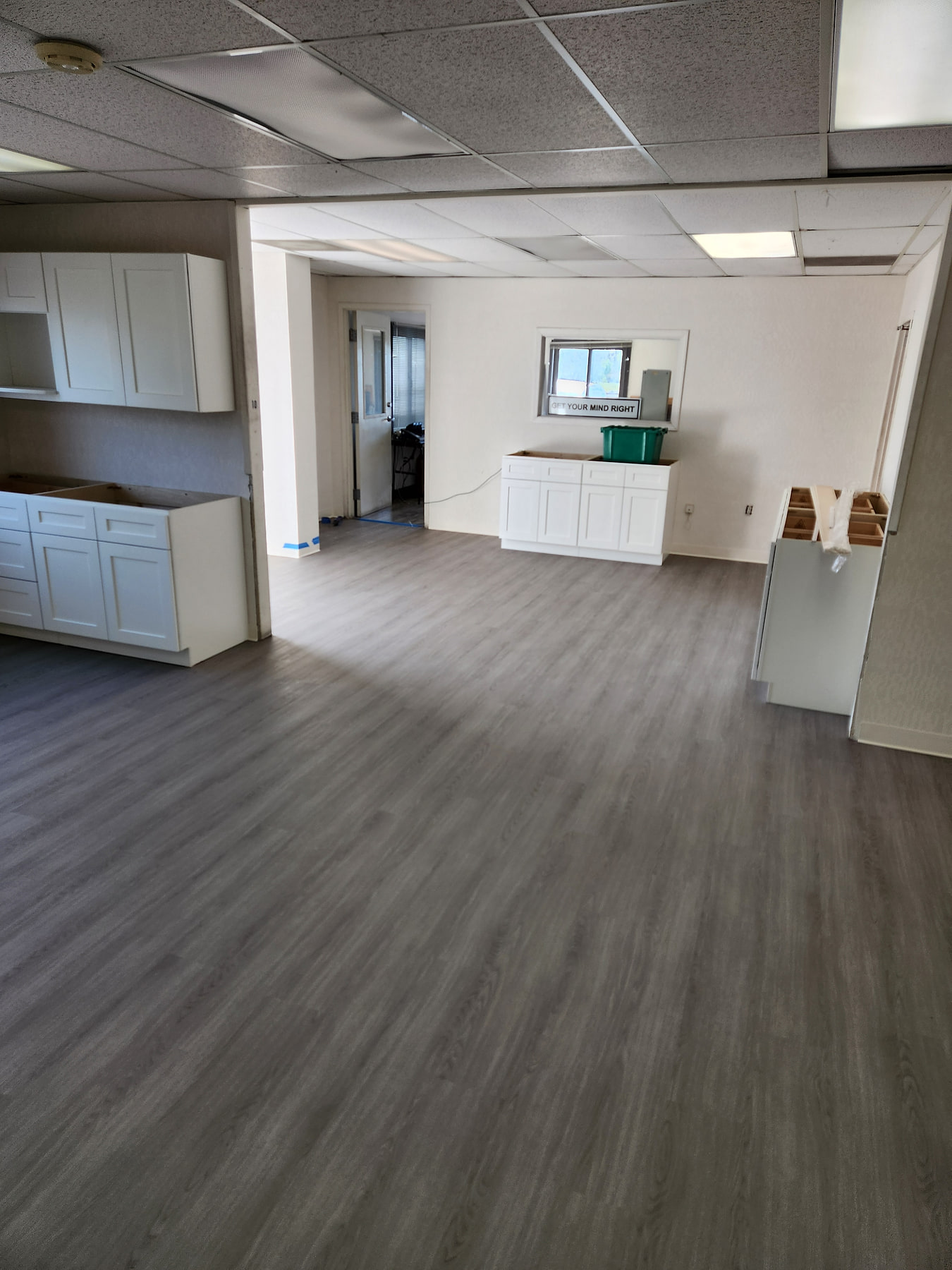 Open-plan commercial space finished in grey glue-down vinyl plank
