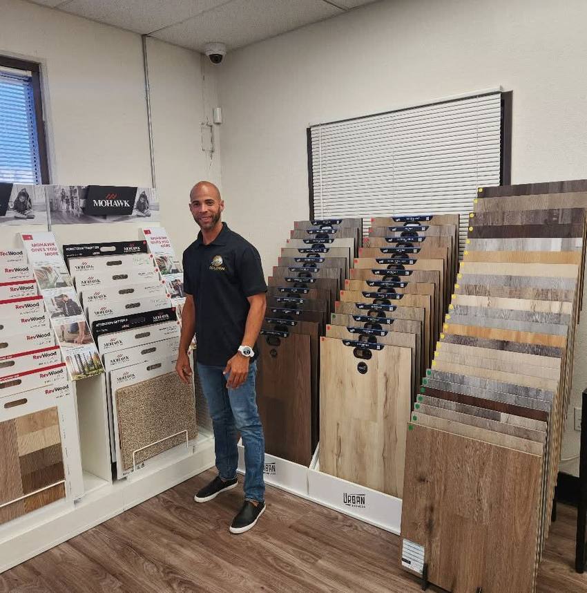 Golden Floors owner among hardwood, laminate and vinyl plank samples at a supplier showroom