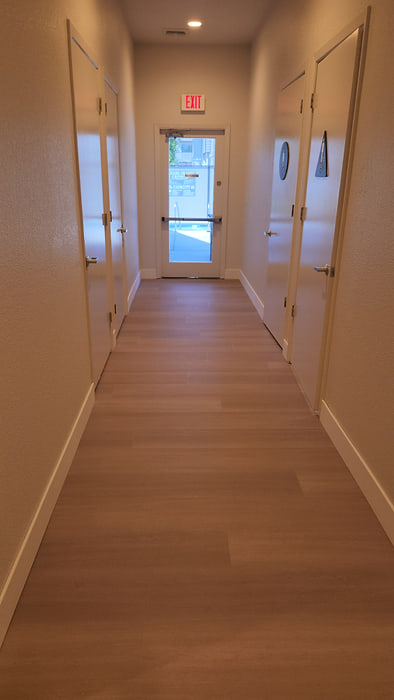 Long multi-unit building corridor finished in wood-look vinyl plank