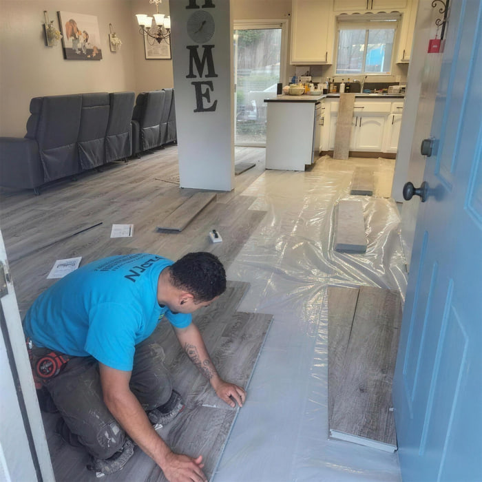 Golden Floors installer laying luxury vinyl plank in a Sacramento living room