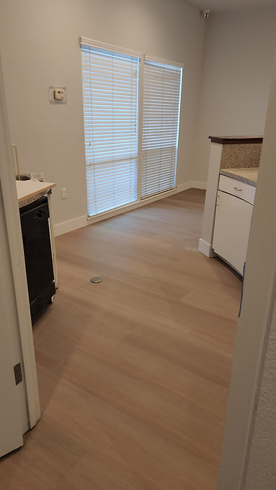 Kitchen with light oak-look vinyl plank flooring and a breakfast bar