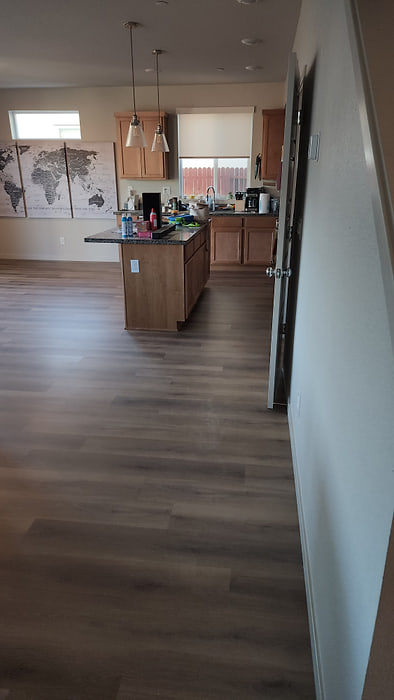 Kitchen with luxury vinyl plank flooring running around a central island
