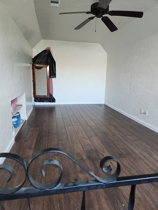Living room with dark wood-look plank flooring fitted around a fireplace