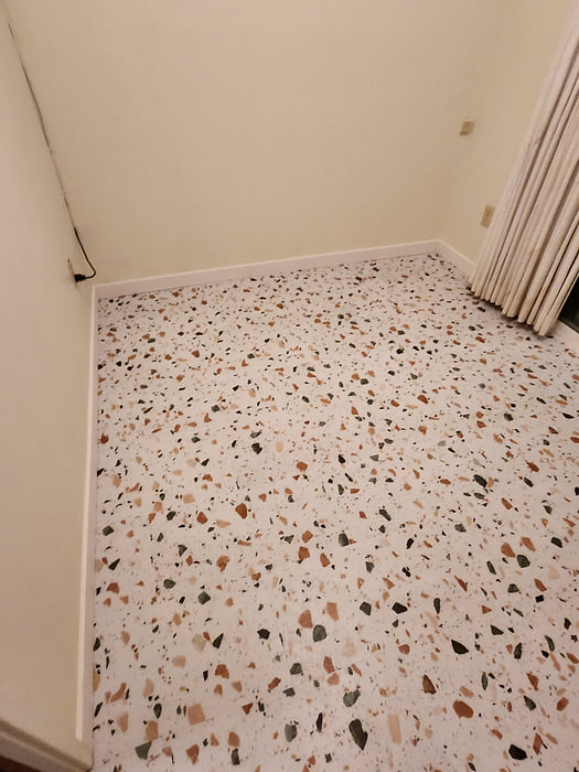 Bedroom corner finished wall to wall in terrazzo-look vinyl flooring